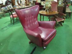 G Plan red leather ‘The Sixty-Two’ wing back swivel armchair. Estimate £100-150