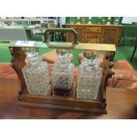 Brass & oak Tantalus with 3 decanters (1 decanter a/f). Estimate £20-30