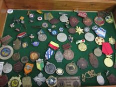 Wooden display case containing a variety of medals & badges. Estimate £20-30