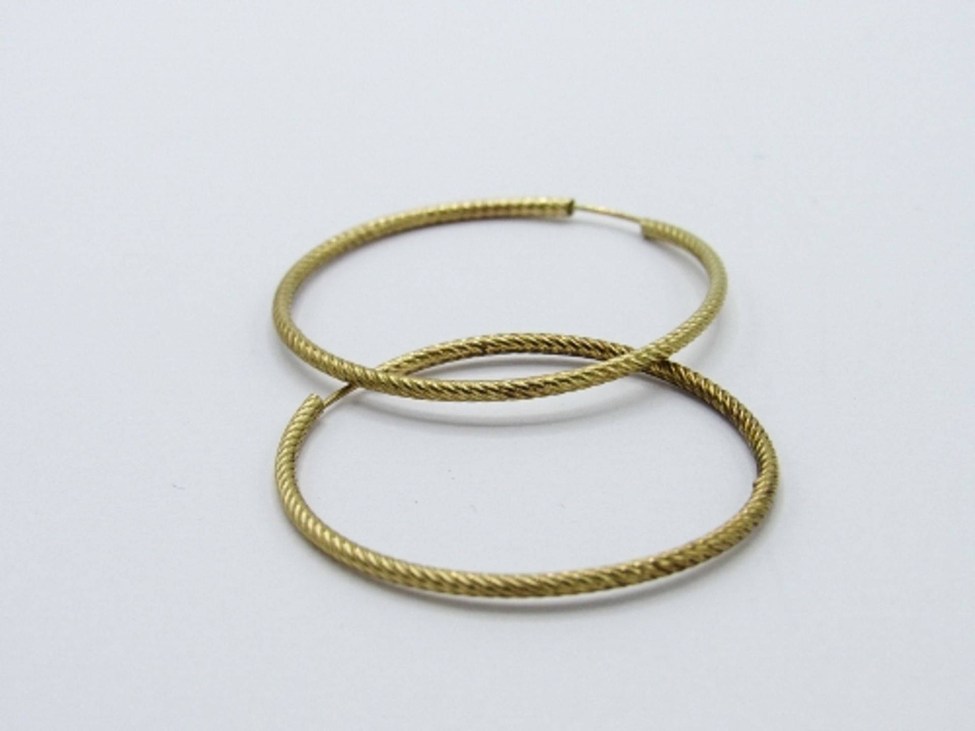 White metal peridot stud earrings with 9ct gold backs & a pair of yellow metal hooped earrings. - Image 3 of 4