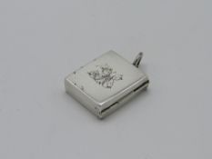 Good Edwardian silver stamp case of hinged rectangular locket form with attached suspension ring.