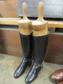 A pair of black riding boots with trees