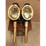 A pair of good quality oval fronted black/brass carriage lamps