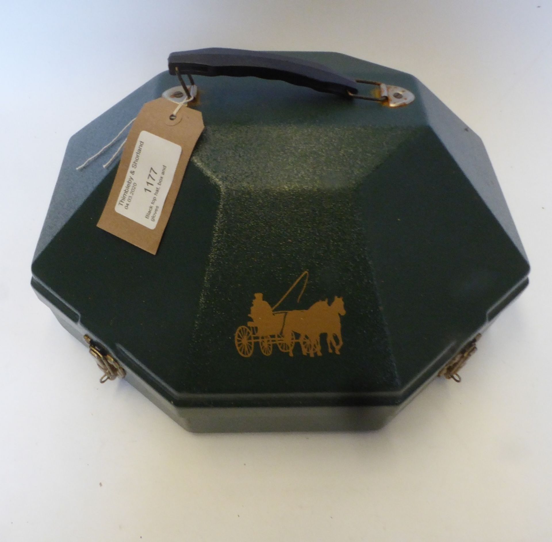Black top hat by Hope Bros., London with a green hat box, plus a pair of brown leather gloves
