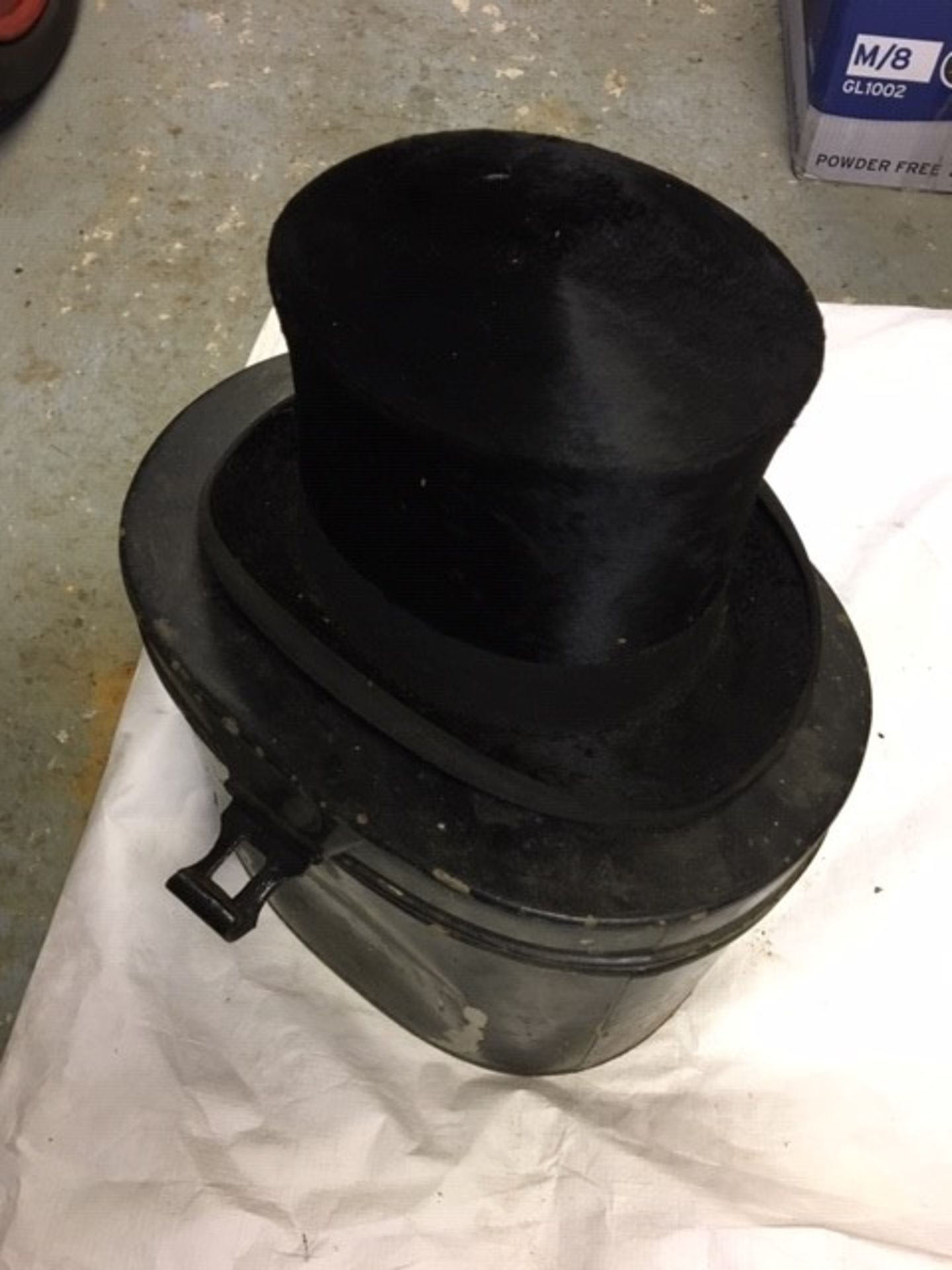 Black top hat in a tin hat box