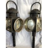 Pair of unusual black/brass trade lamps with round fronts and carry handles (view in security pen)