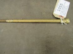 A side saddle whip with a cream-coloured plaited whalebone handle and embossed gilded butt cap and