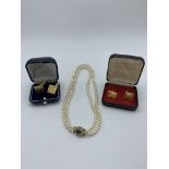 Twin string of pearls with 9ct gold clasp set with seed pearls and an oval red stone, together