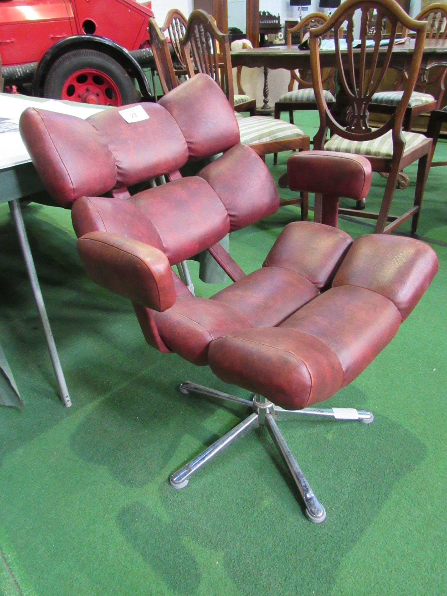 1970's style red vinyl armchair on chrome pedestal. Estimate £40-60.