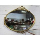Decorated gilt framed oval shaped wall mirror. Estimate £10-20.