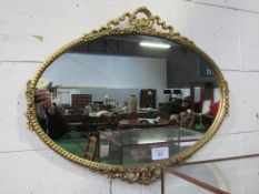 Decorated gilt framed oval shaped wall mirror. Estimate £10-20.