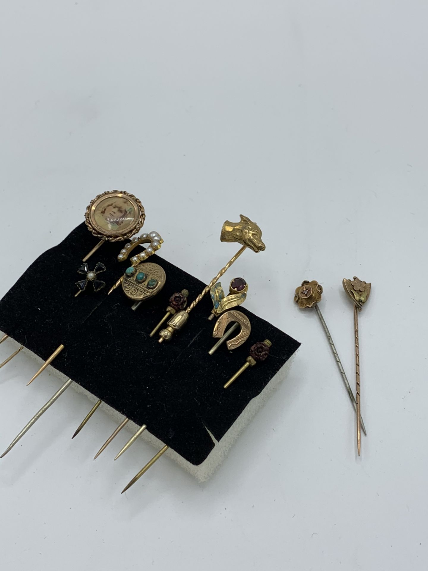 2 x 9ct gold stick pins and 9 others. Estimate £20-30.