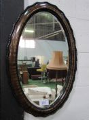 Oval shaped bevelled edge mirror in tortoise shell effect frame. Estimate £20-30