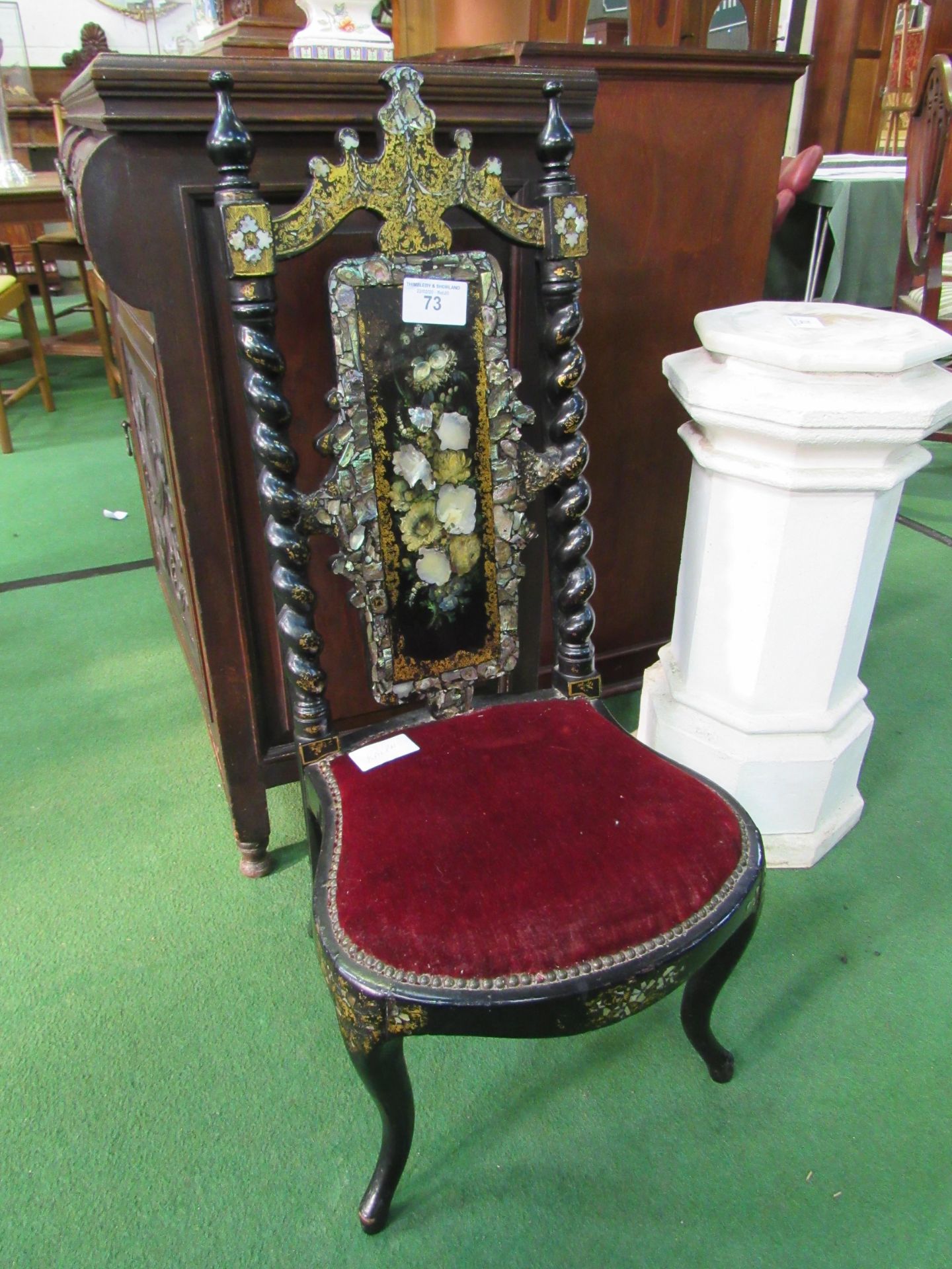 Ebonised and mother of pearl inlaid low chair. Estimate £20-30.