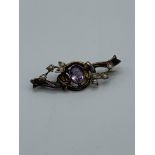 9ct gold seed pearl and purple stone brooch. Estimate £20-30.