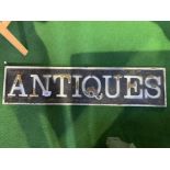 Metal ""Antiques"" sign, raised letters. 29 x 121cms. Estimate £30-50.