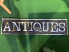 Metal ""Antiques"" sign, raised letters. 29 x 121cms. Estimate £30-50.