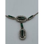 Diamond and emerald necklace on a 9ct gold chain. Estimate £850-900.