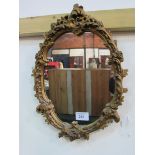 Oval ornate gilt framed wall mirror. Estimate £10-20.