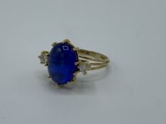 18ct gold ring set with large blue stone and a diamond either side. 17mm x 13mm, weight 7.6gm,