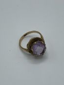 9ct gold and large pale purple stone ring. Estimate £30-50.