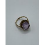 9ct gold and large pale purple stone ring. Estimate £30-50.