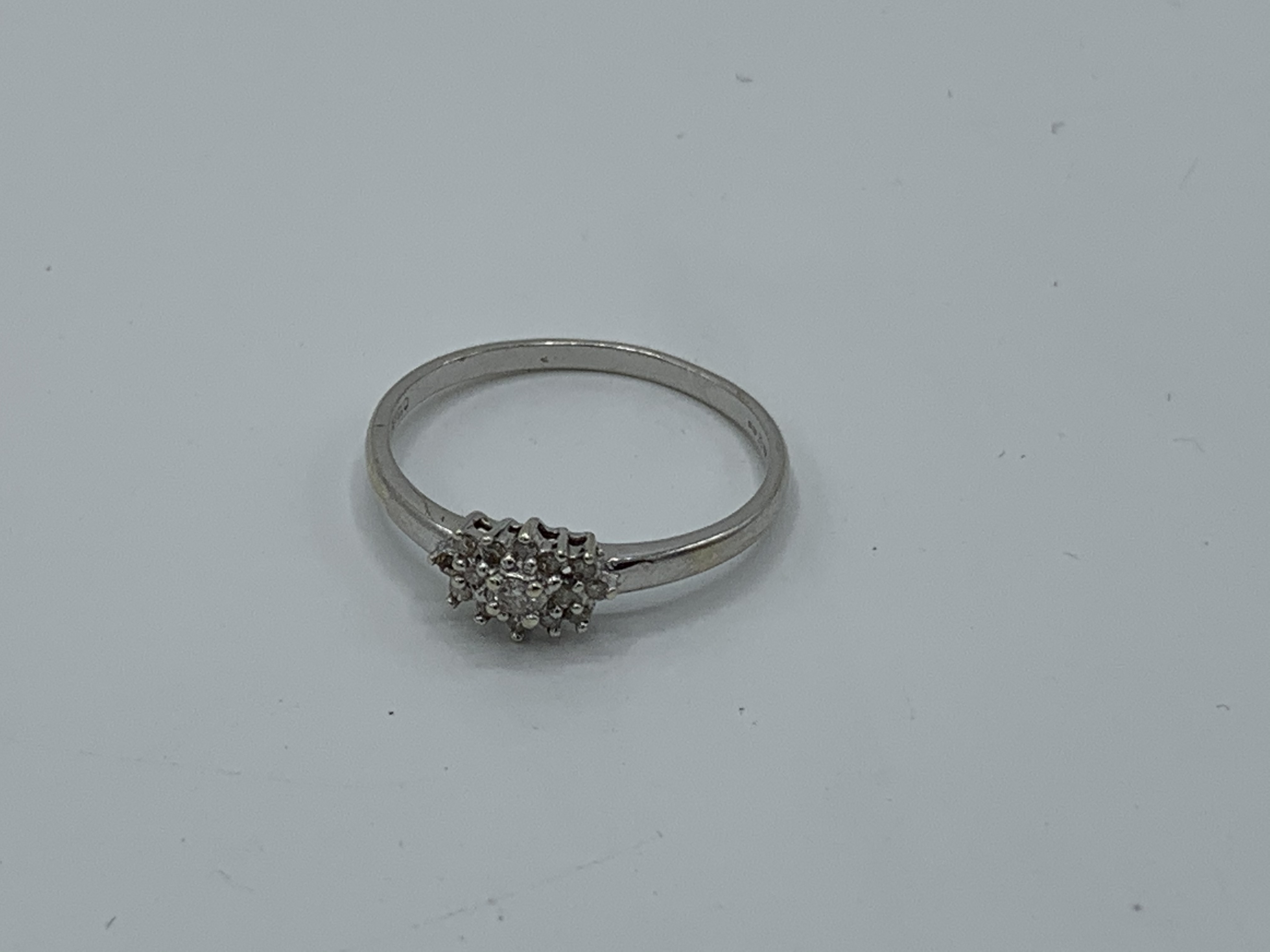 9ct white gold petite cluster ring, size R, weight 1.7gms. Estimate £50-70.