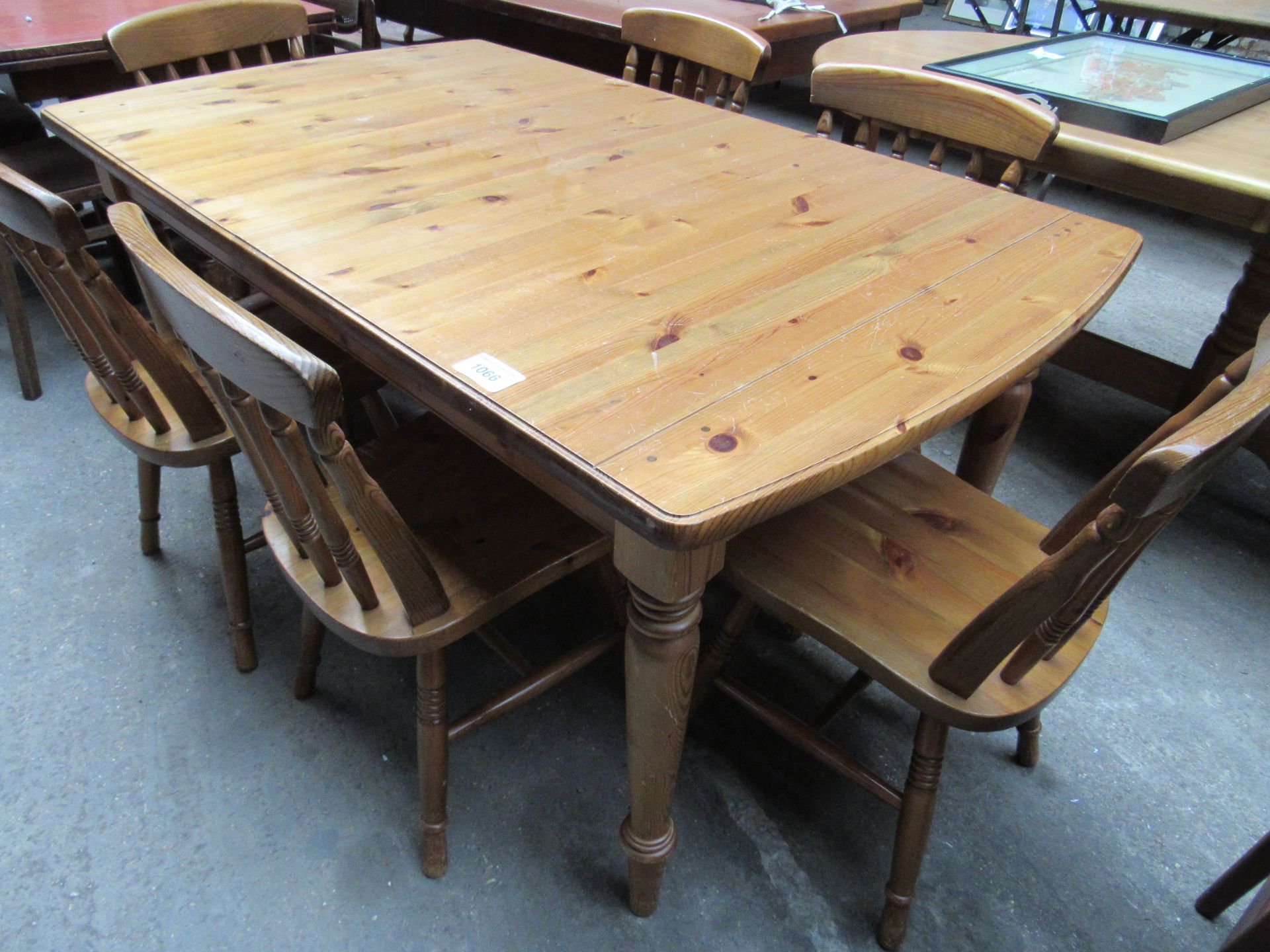 Pine extending kitchen table with six farmhouse chairs.