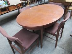 Hardwood extending oval table with four Scandart Ltd chairs.