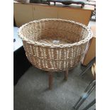 Wicker basket on stand, diameter 56cms, height 73cms.