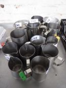 13 stainless steel jugs. Estimate £20-25.