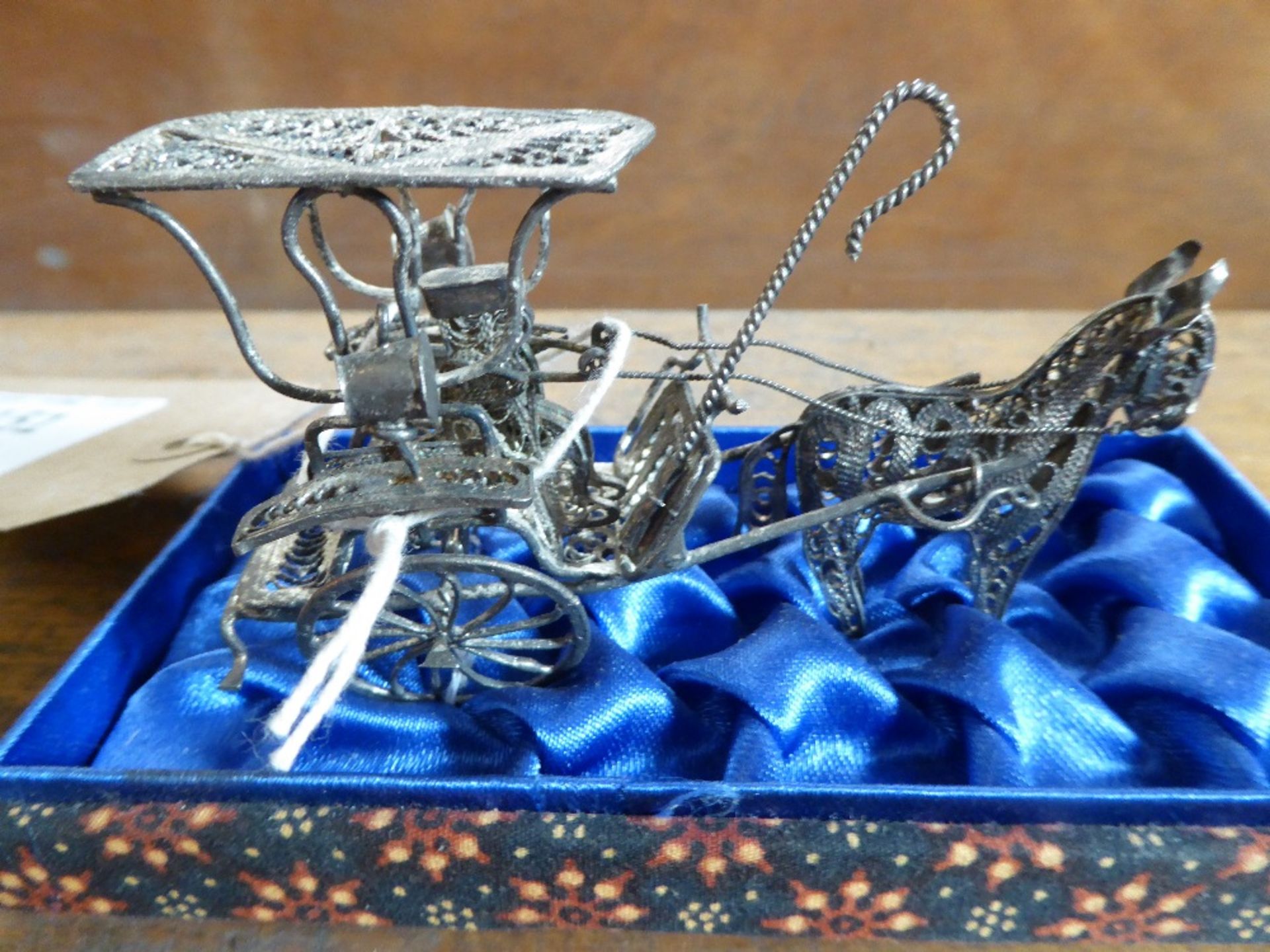 Silver coloured metal model of a donkey and carriage