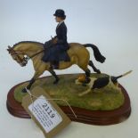 Border Fine Arts model of a lady riding side saddle on a Dun horse with a hound by her side, on a