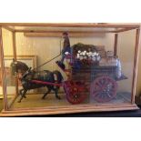 A detailed model of a Fruiterers & Greengrocers cart with driver and horse displayed in a glass
