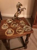 Assortment of brass items including coach horn, figurine of a rearing horse and seven horse brasses