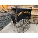 MILK PRAM with wooden body on 3 metal shod wheels. In original condition, sign written 'Express
