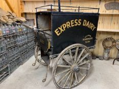 MILK PRAM with wooden body on 3 metal shod wheels. In original condition, sign written 'Express