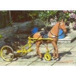 Early 20thC child's ride-on pedal horse in harness with driving reins, pulling a two-wheel pedal