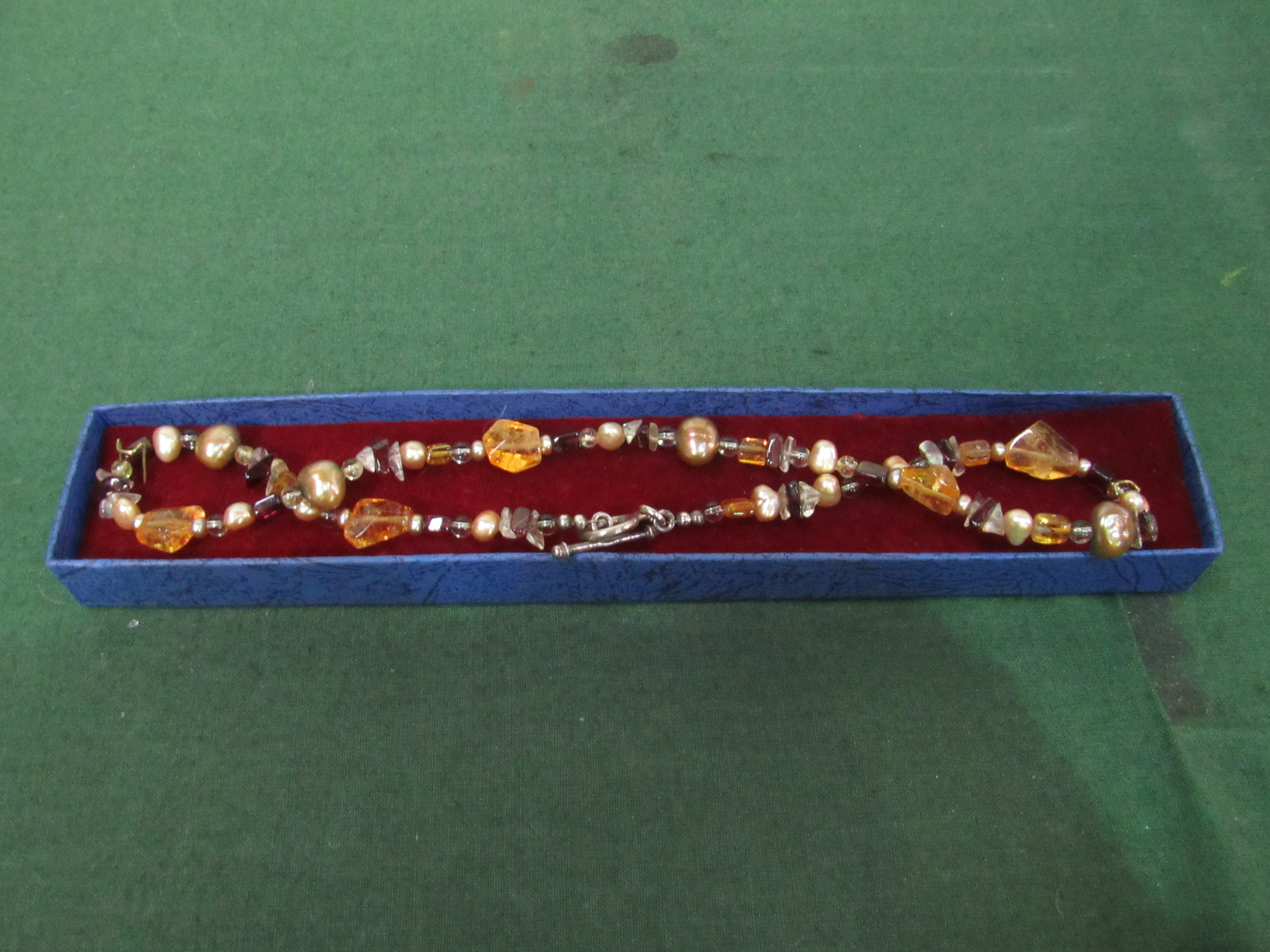 Necklace of semi-precious stones, amber and freshwater pearls. Estimate £15-30.