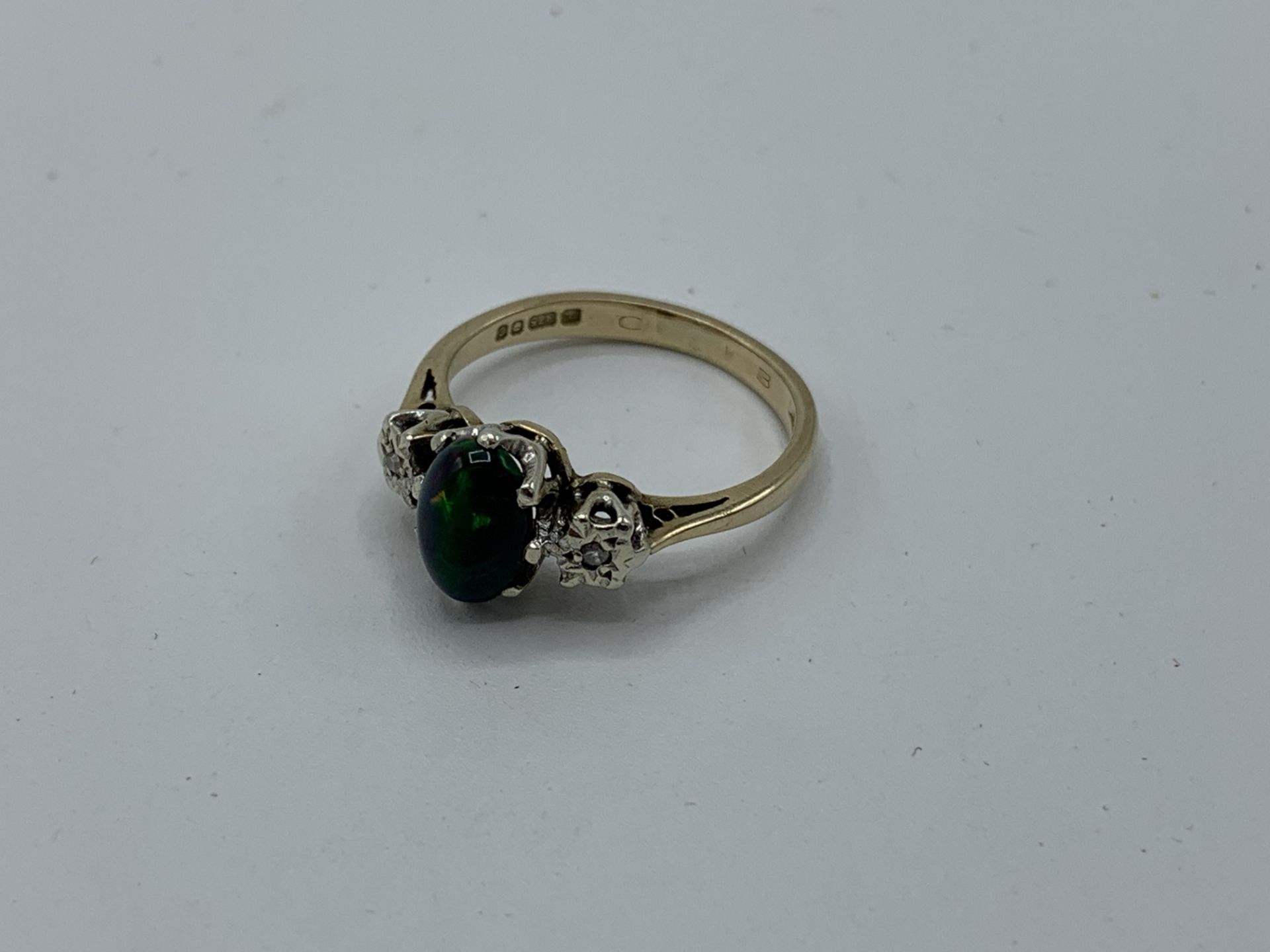 9ct gold ring with centre black opal and diamond either side, weight 2.5gms, size L 1/2. Estimate £