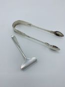 Georgian silver sugar tongs, 1.5ozt, together with a silver child's food ""pusher"", 0.5ozt.