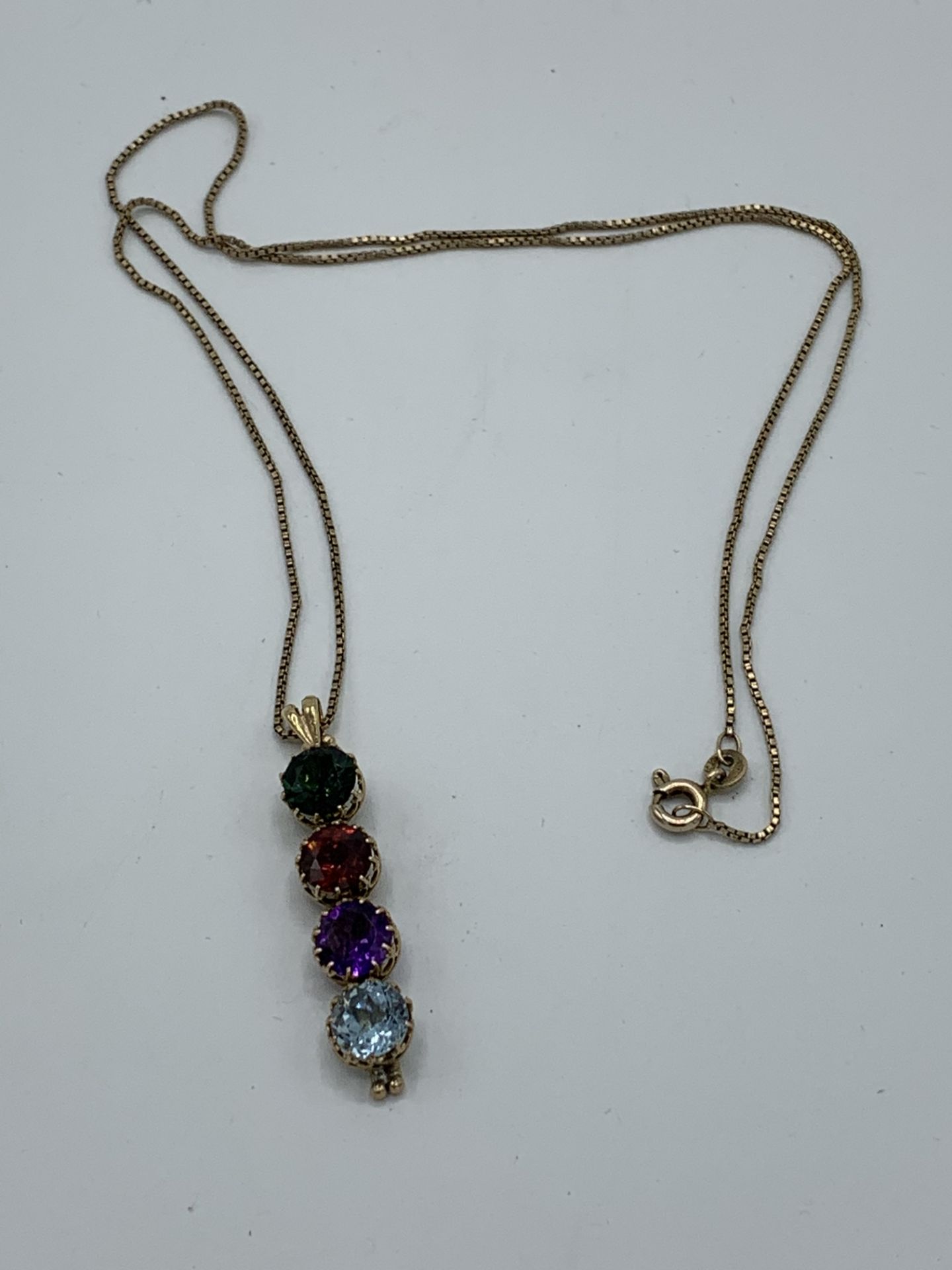 Yellow metal 4 gemstone pendant on a 9ct gold chain, chain length 48cms. Estimate £250-280.