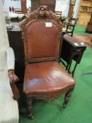 Leather upholstered heavily carved dining chair. Estimate £20-30.