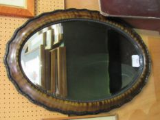 Oval shaped bevelled edge mirror in tortoise shell effect frame. Estimate £20-30