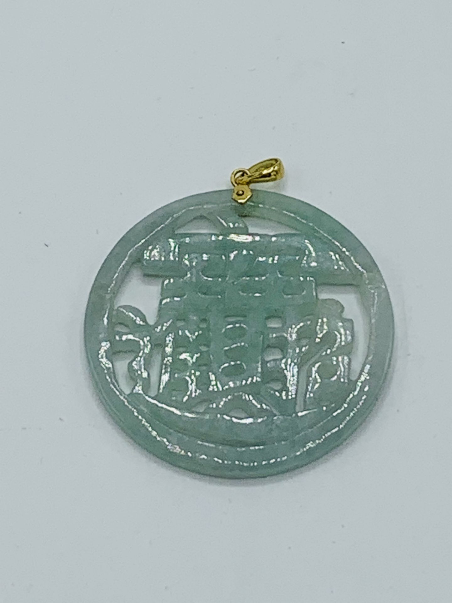 14ct gold jade pendant. Estimate £30-40.