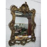 Large ornate gilded serpentine shape gilt frame mirror. Estimate £20-30.