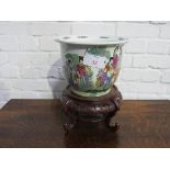 Large round Chinese Famille Verte fish bowl or Jardinière on ornate wood stand. Estimate £30-50.
