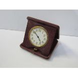 Vintage travelling clock in red leather case. Estimate £90-110.