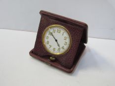 Vintage travelling clock in red leather case. Estimate £90-110.