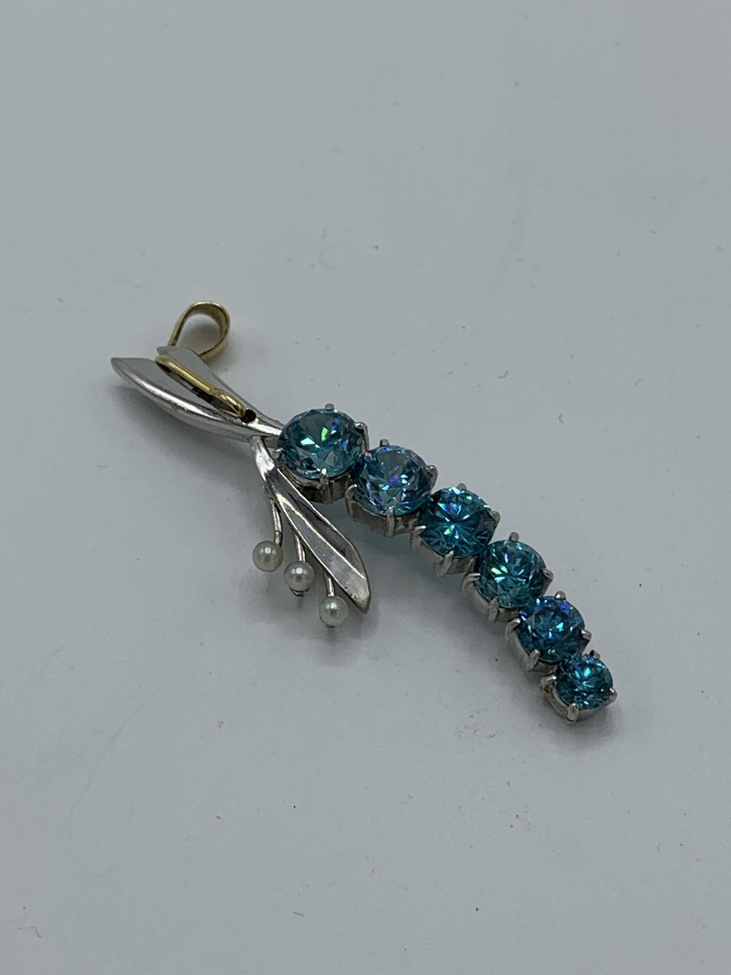 Blue zircons and pearl pendant. Estimate £300-350.